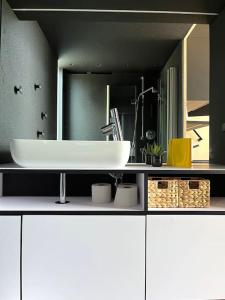 a bathroom with a sink and a large mirror at KODA Concrete villa by the river with sea view in Papsaare