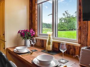 Scorton的住宿－Beverleys Hideaway - Uk44691，一张桌子,上面放有盘子和酒杯,还有一个窗口