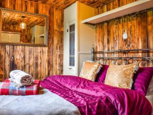 a bedroom with a bed with purple sheets and a mirror at Beverleys Hideaway - Uk44691 in Scorton