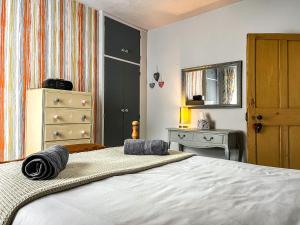 a bedroom with a bed and a dresser and a mirror at Regent House in Leek