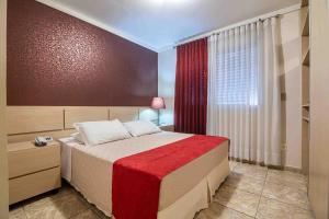 a bedroom with a large bed with a red blanket at Bela Vista Flat in Porto Alegre