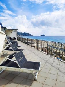 una fila de tumbonas en un balcón con vistas al océano en Hotel Premuda, en Spotorno