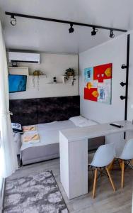 a bedroom with a bed and a desk and chairs at Къмпинг за Каравани и Кемпери Барите - Caravan Pitch Park Barite in Varna City
