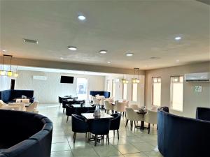 a dining room with tables and chairs and a restaurant at KAVIA MEOQUI HOTEL & SUITES in Meoqui