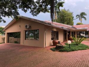 a house with a brick driveway in front of it at Tzaneen Guest House in Tzaneen