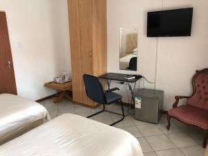 a hotel room with a bed and a desk and a chair at Tzaneen Guest House in Tzaneen
