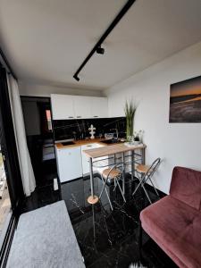 a kitchen with a table and chairs and a couch at HM - Tinyhouse 1 Deluxe Krombachtalsperre Westerwald in Driedorf
