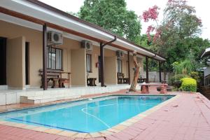 a swimming pool in front of a house at Tzaneen Guest House in Tzaneen