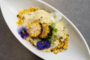 - un bol blanc de nourriture avec du maïs et des fleurs violettes dans l'établissement Boca Raton Marriott at Boca Center, à Boca Raton