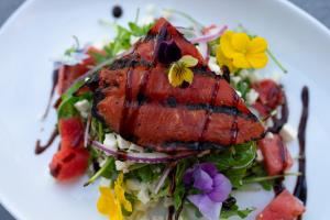 a plate of food with a salad with flowers on it at Boca Raton Marriott at Boca Center in Boca Raton +123 photos