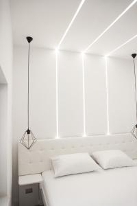 a white bedroom with a white bed and two lights at Elite estate in Podstrana