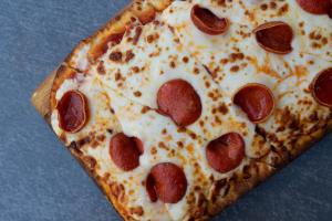 a pepperoni pizza sitting on top of a table at Boca Raton Marriott at Boca Center in Boca Raton