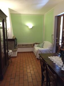 a green room with a bed and a table at Agriturismo Poggio Paradiso in Mengara