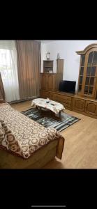 een slaapkamer met een bed en een tafel. bij Apartament in Craiova