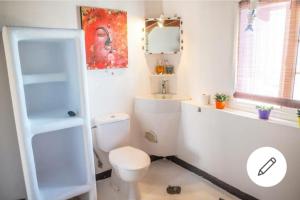a white bathroom with a toilet and a sink at Loft near the BEACH in La Mareta