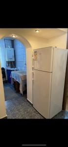 een witte koelkast in een keuken met een tafel bij Apartament in Craiova