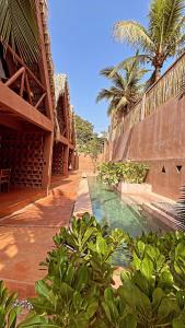 a swimming pool next to a building with palm trees at Punta Navi - Adults only - Boutique hotel in Puerto Escondido