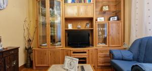 a living room with a tv in a wooden entertainment center at La Xana del Arbeyal - Apartamento ideal Para 3 pax in Gijón