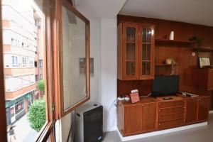 Habitación con TV, armario y ventana. en STAY Benavente, en Oviedo
