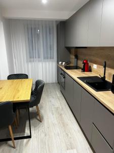 a kitchen with a table and chairs and a counter at Traian Taranu Apartment in Suceava