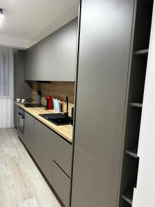 a kitchen with black and white cabinets and a counter at Traian Taranu Apartment in Suceava