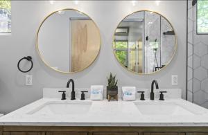 La salle de bains est pourvue de 2 miroirs et d'un lavabo. dans l'établissement Tara's Treehouse near Asheville, à Fairview