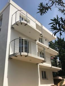 un edificio bianco con balcone di Guesthouse - Hotel California a Novalja (Novaglia)