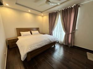 a bedroom with a bed and a window at 2 Bed Apartment near Gulberg in Lahore