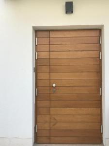 a wooden garage door in a white wall at Guesthouse - Hotel California in Novalja