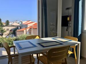 a dining room table with chairs and a window at Guesthouse - Hotel California in Novalja