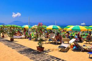 un grupo de personas sentadas en una playa con sombrillas en Casa vacanze Vannucci, en Balestrate