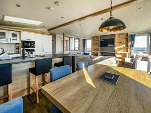 eine Küche und ein Wohnzimmer mit einem Holztisch in der Unterkunft Solway Heights 7 - Uk43974 in Mainsriddle