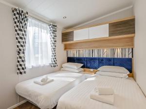 2 Betten in einem kleinen Zimmer mit weißer Bettwäsche in der Unterkunft Solway Heights 7 - Uk43974 in Mainsriddle