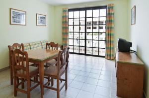 una sala da pranzo con tavolo, sedie e finestra di Apartamentos Las Mozas a Valle Gran Rey