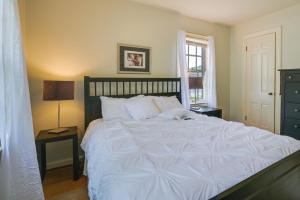 a large white bed in a bedroom with a window at Cumberland Cottage with Screened Porch and Fire Pit! in Cumberland