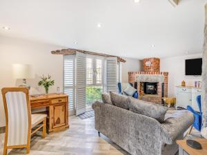 a living room with a couch and a table and a fireplace at Goosehill Fold in Normanton