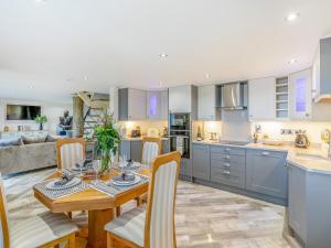 a kitchen and living room with a wooden table and chairs at Goosehill Fold in Normanton