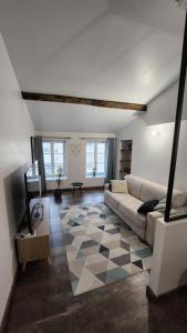 uma sala de estar com um sofá e um piso em xadrez em Charmant appartement au cœur de ville de Toul em Toul