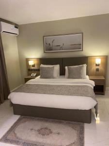a bedroom with a large bed with two pillows at Knightsbridge Hotel & Suites in Abuja