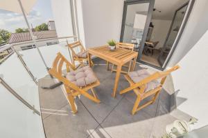 d'un balcon avec une table et des chaises en bois. dans l'établissement Luxus Apartment Bad Salzuflen, à Bad Salzuflen