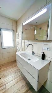 a white bathroom with a sink and a mirror at Häuschen am Plenzer in Ingelheim am Rhein