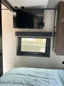 a bedroom with a bed and a window in an rv at RV3 Wonderfull RV in MOVAL private freeparking Netflix in Moreno Valley