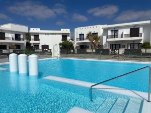 a large swimming pool in front of a building at Casa Inma Las Piteras. Sol y agua in Costa Teguise