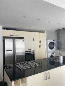 a kitchen with a stainless steel stove and refrigerator at Relax Sea View 3BR in Gordon Beach by Holyguest in Tel Aviv