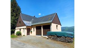 uma grande casa branca com um telhado de gambrel em Chalet de 3 chambres avec jardin clos et wifi a Kruth em Kruth