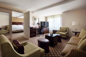 ネイパービルにあるChicago Marriott Napervilleのベッドとリビングルームが備わるホテルルームです。