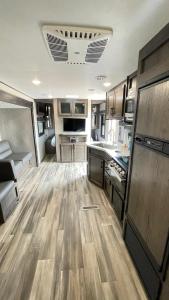 a large kitchen with wooden flooring in an rv at RV3 Wonderfull RV in MOVAL private freeparking Netflix in Moreno Valley