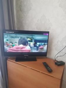 uma televisão de ecrã plano em cima de uma cómoda em Квартира в центре левого берега Астаны Туран, 46А em Taldykolʼ