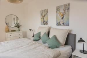 a bedroom with a bed with pillows and a mirror at Luxus Apartment Bad Salzuflen in Bad Salzuflen