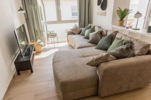Luxus Apartment Bad Salzuflen في باد سالزوفلين: غرفة معيشة مع كنب بني